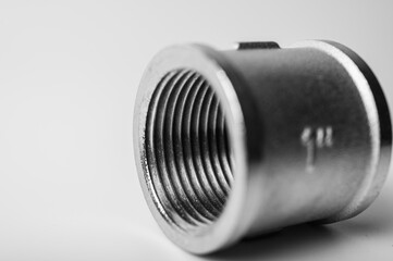 black and white photo, brass metal plugs, joints, adapters, hex key plugs for water isolated on light background close up plumbing connections and parts