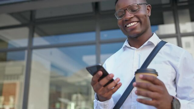 Phone, coffee and black man laughing in city at funny meme, comedy or joke. Business tea, 5g cellphone and happy male professional with mobile smartphone for comic video, social media or web browsing