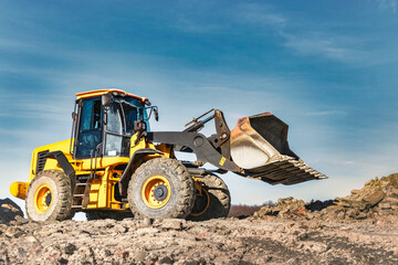 Powerful wheel loader or bulldozer working on a quarry or construction site. Earthworks in construction. Powerful modern equipment for earthworks.