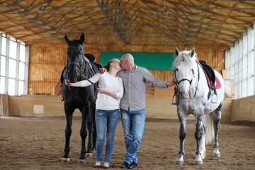 People on a horse training in a wooden arena