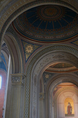 Monumental church building in Gothic in neo-romanesque arch style with large ceiling and altar murals and fresco, opulent detailed columns and marble structures