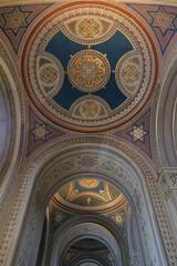 Monumental church building in Gothic in neo-romanesque arch style with large ceiling and altar murals and fresco, opulent detailed columns and marble structures