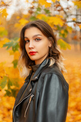 Autumn female portrait of pretty stylish girl in fashion black leather jacket in yellow fall park