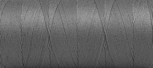 Texture of threads in a spool of grey color on a white background