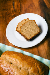 Homemade sponge cake in blue ceramic mold on wooden table. Sliced Pound cake.