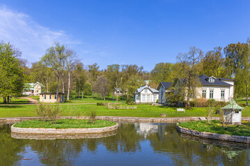 Fototapeta na wymiar Old idyllic houses by a pond in a park