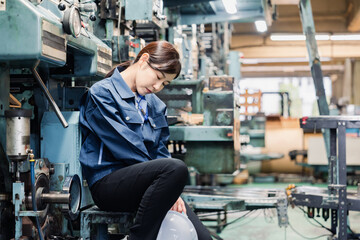 Fototapeta na wymiar 過労でやる気をなくす工場労働者の女性