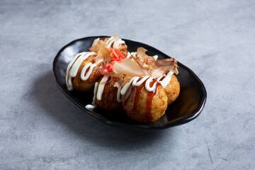 A view of a plate of takoyaki.