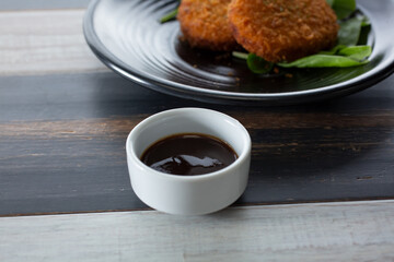 A view of a condiment cup of hoisin sauce.