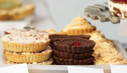 Forest fruit tarts, chocolate tarts with salt caramel and lemon tarts on display at the pastry stand at the farmers street food market in Prague. No people, no AI.