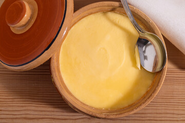 .Pure OR Desi Ghee also known as clarified liquid butter. Pure OR Desi Ghee in ceramic bowls on an...