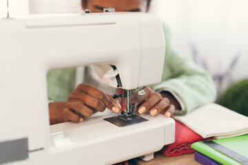 Hand African American woman fashion designer clothes working with sewing in own dressmaking studio or boutique	