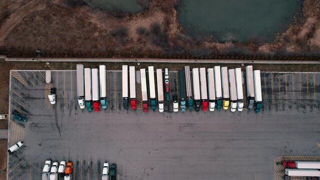 Static aerial of top down truck stop aerial view. Carhauler, dryvan, reefers, flatabed, bobtails parked. USA 4k Aerial
