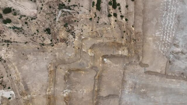 Drone Flying Along An Old Quarry In South Australia. Top Down Camera View Looking Directly Down, While Drone Flies Forwards. Blue Cloudy Sky Above. Vegetation Is Growing In The Old Quarry.