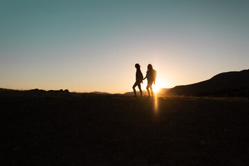 two people walk along a mountain range