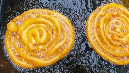 Deep oil frying jilebi or jilapi indian sweet traditional food with smooth motion clip.