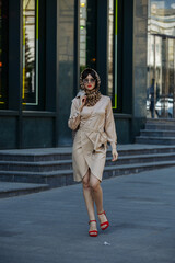 A girl in sunglasses walks the streets of the city