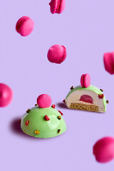 Mousse dessert on a pink background in a composition with small macaroons