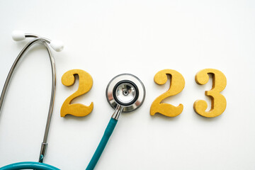 New Year 2023 golden numbers 2023 with Stethoscope on white background. Happy New Year and healthy medical concept.