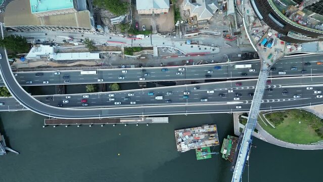 Top down drone shot from above Brisbane Expressway Motorway. With Brisbane City's Queens Wharf Development in shot. Neville Bonner Bridge in shot. Busy traffic on the motorway below.