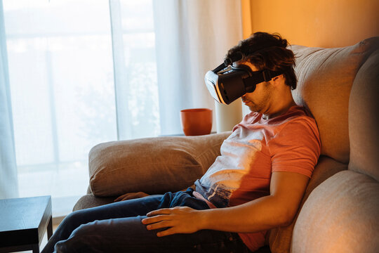 Man using virtual reality while sitting on sofa at home