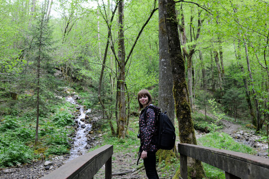 Side view of woman with backpack standing in forest