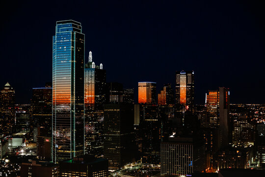 Digital composite image of illuminated modern buildings against sky at night