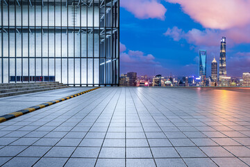 City square and glass wall with the city skyline at night in Shanghai, China. High Angle view.
