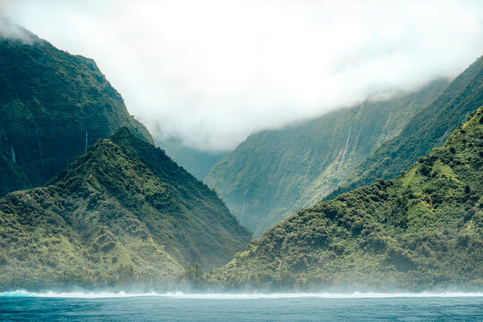 Scenic view of sea by mountains against cloudy sky