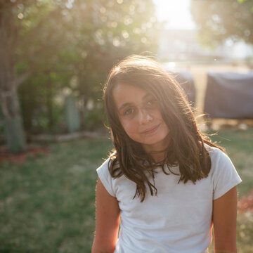 Portrait of smiling girl standing at playground during sunny day