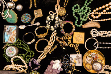 Golden vintage colorful jewelery on black velvet.