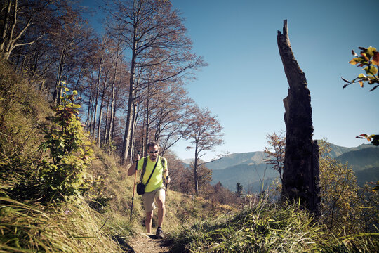 Man hiking on mountain against clear blue sky during sunny day