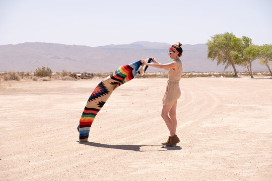 girl laying out blanket in desert