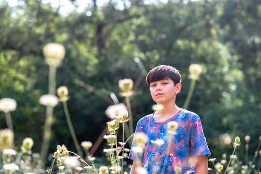Young teen looking through plants deep in thoughts