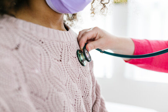 Stethoscope placed directly over biracial child's heart beat to listen