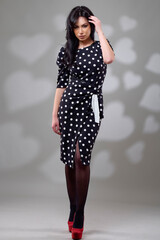 an elegant brunette woman in a dress in the studio