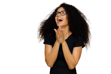 Overjoyed beautiful woman clasps hands, laughs joyfully, looks away, focused aside, expresses happiness, has bushy curly hair, wears casual clothes, spectacles, isolated over brown background
