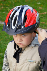 A little boy with a bicycle helmet and enjoying the warm summer weather and sun. It's summer break.