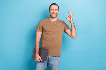 Photo of young guy wear brown t-shirt brunet hair show okey sign hold netbook eshopping advert hp...