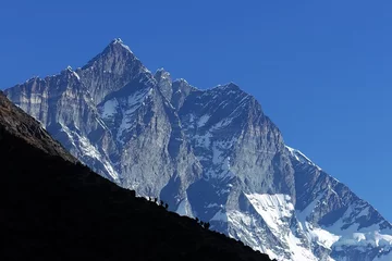 Photo sur Plexiglas Lhotse A group of trekkers climbing up to Nangkartshang Peak with Mt. Lhotse, Nepalese Himalayas