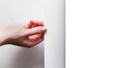 Hand pulling white page to reveal and show your design. Transparent background