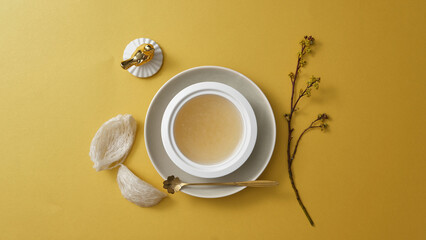 Top view of bird's nests and bird’s nest soup, small flower branch on yellow background. Swallow's nest is one of most important traditional supplements for longevity and youth. Healthy herbal. © Tuan  Nguyen 