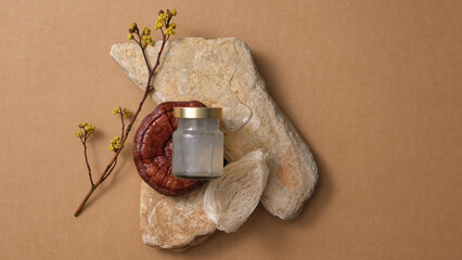 Fototapeta na wymiar Scene mockup for product with bird's nest water bottle and red reishi mushroom (Ganoderma lucidum) put on stones, on brown background. A luxury food from nature. Top view, flat lay.