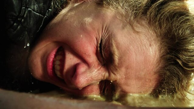 Close up caucasian woman falling in a mud puddle, slow motion