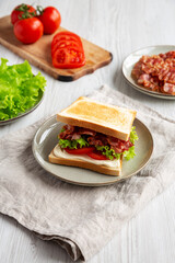 Homemade BLT Sandwich (Bacon, Lettuce and Tomato) on a Plate, side view.