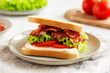 Homemade BLT Sandwich (Bacon, Lettuce and Tomato) on a Plate, side view.