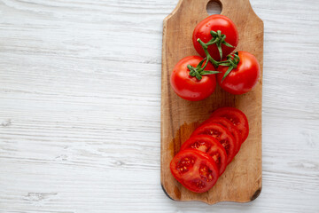 Raw Red Organic Tomatoes on a Rustic Wooden Board, top view. Flat lay, overhead, from above. Copy space.