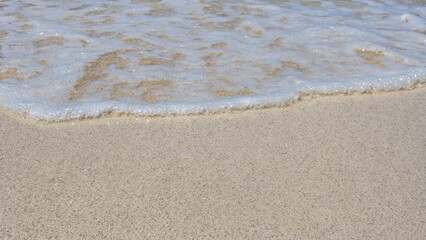 beautiful view, close-up of crystal clear sand and water in the sea, surf on a sunny day,