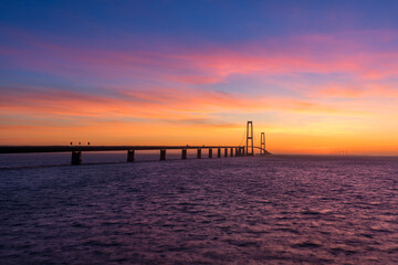 Fototapeta na wymiar The Great Belt bridge in Denmark during a very colorful sunset