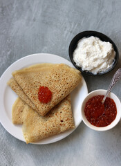 Shrove Tuesday celebration. Tiny Crepes on a plate. Festive food close up photo. 